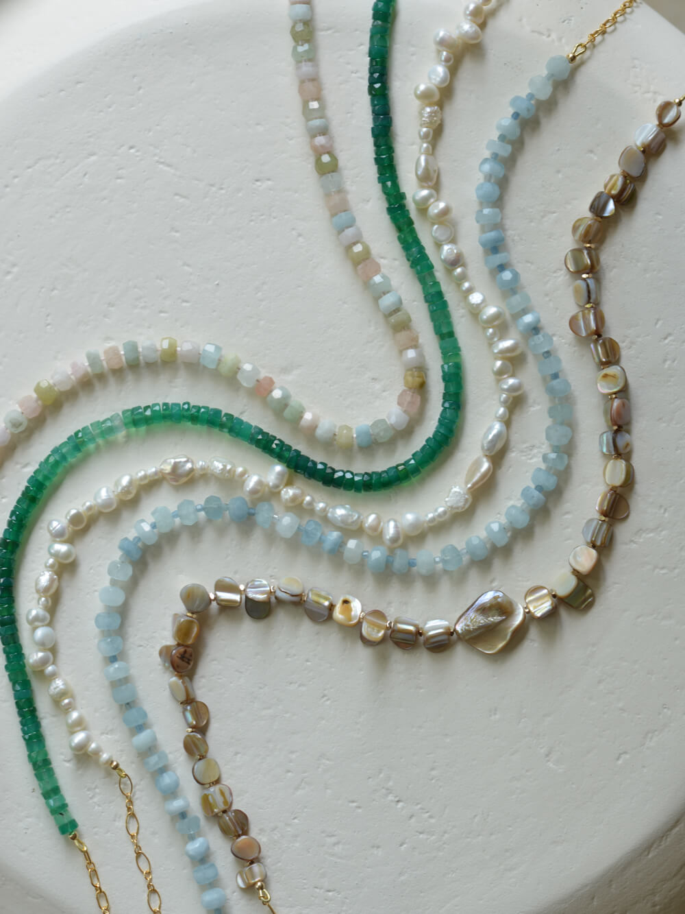 Necklace flatlay with pearls, aquamarine, and green chalcedony