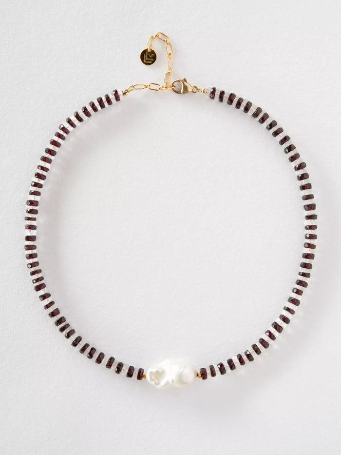 Necklace with garnet and crystal beads and a gold clasp on a white background