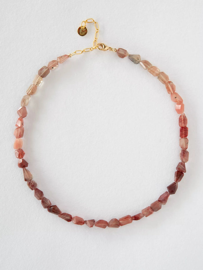 Necklace with pink and gold beads on a white background