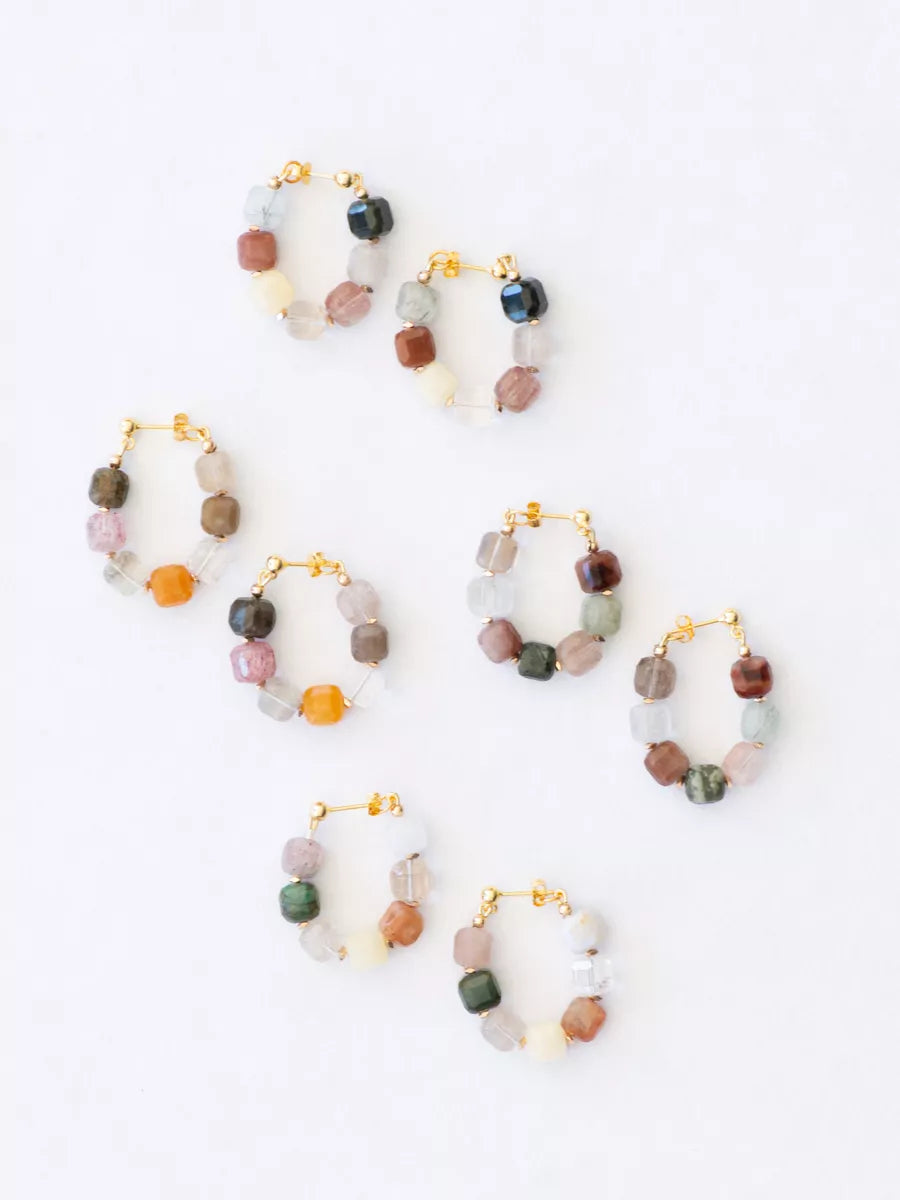 Set of multicolored beaded hoop earrings on a white background