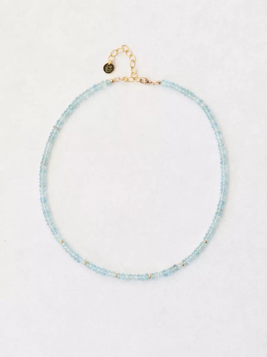 Aquamarine necklace with gold finishing on white background.