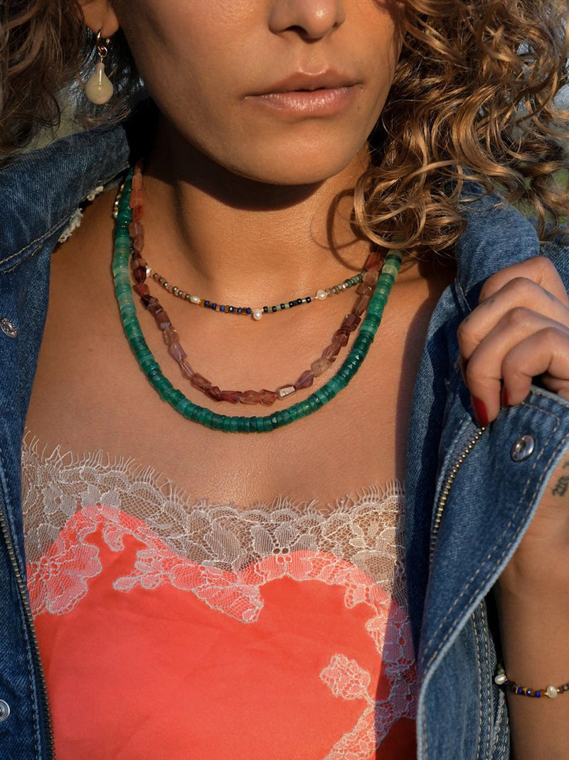 Close up of model wearing Banded Baby Gems Necklace, facted andesine necklace, and green chalcedony necklace.  