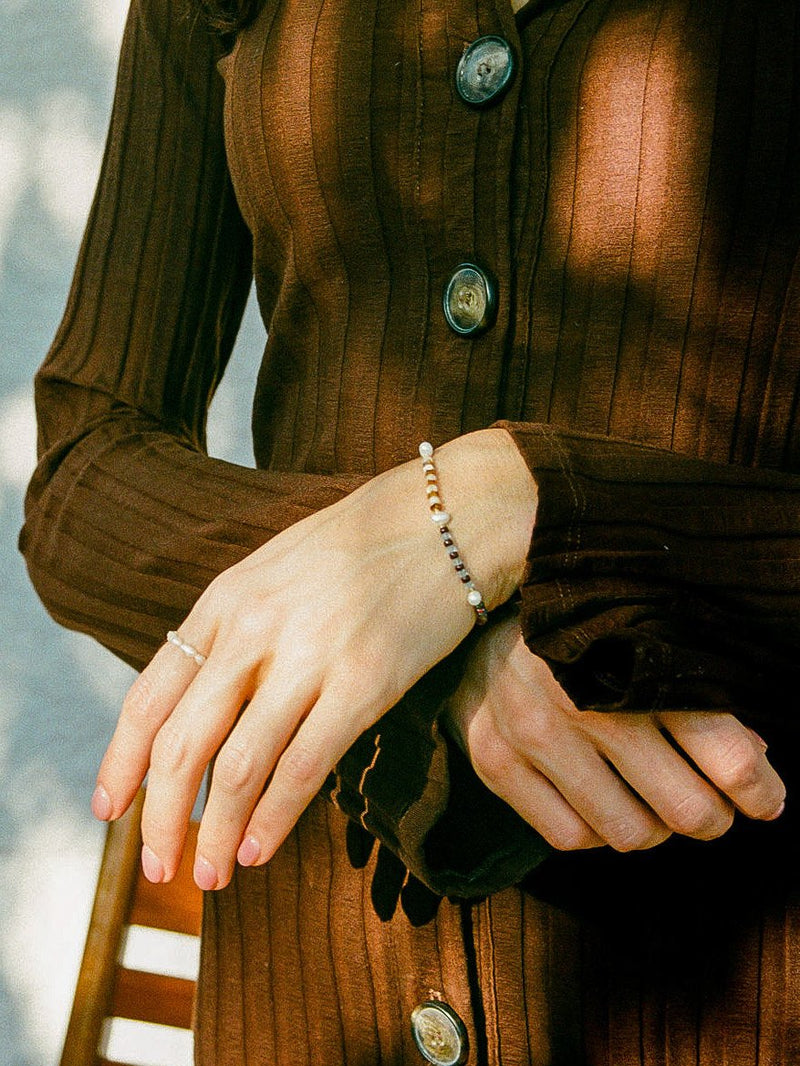 Model wearing Banded Baby Gems bracelet and brown sweater.
