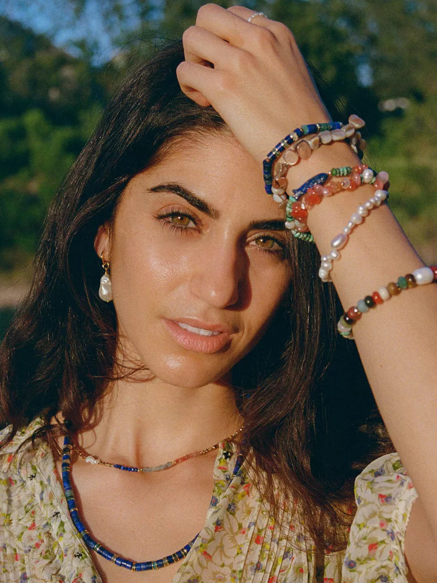 Woman wearing colorful bracelets and a necklace outdoors