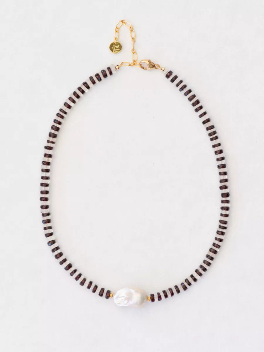 Necklace with garnet and crystal beads on a light gray background