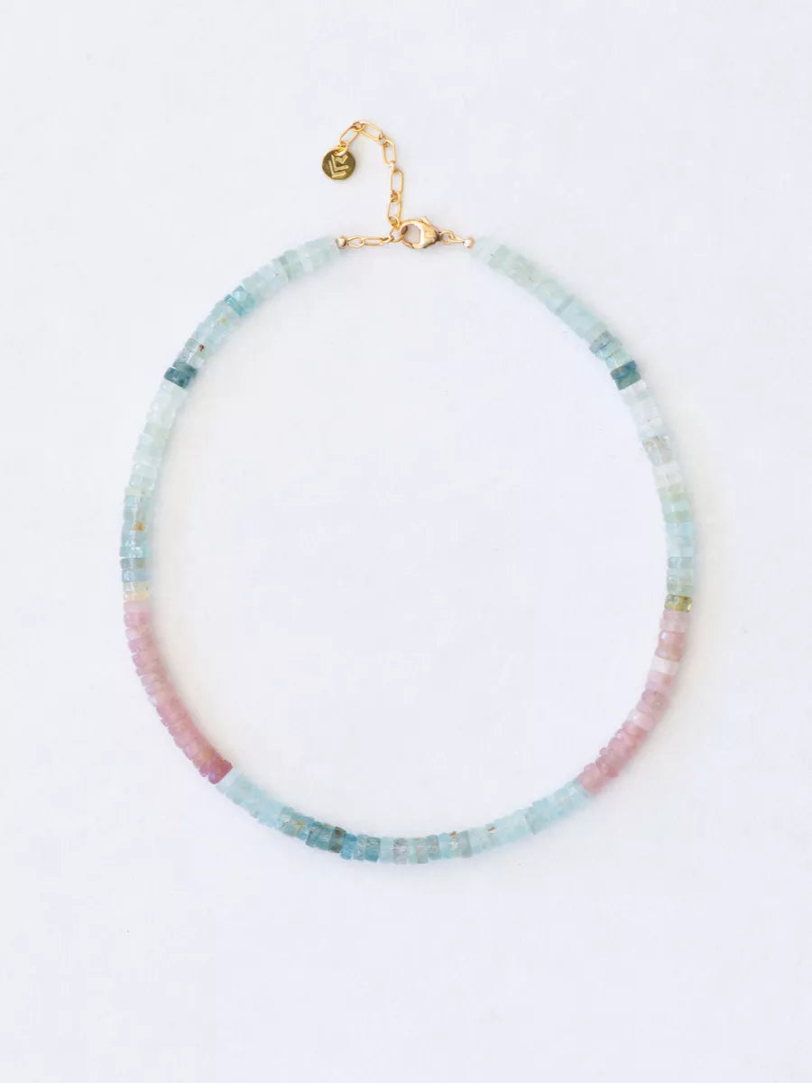 Beaded necklace with gradient from pink the aqua blue on a white background.