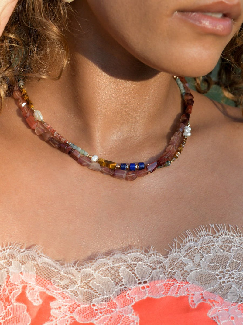 Close up of a model wearing Heartstone Gradient Andesine Necklace and Luxe baby gems necklaces.