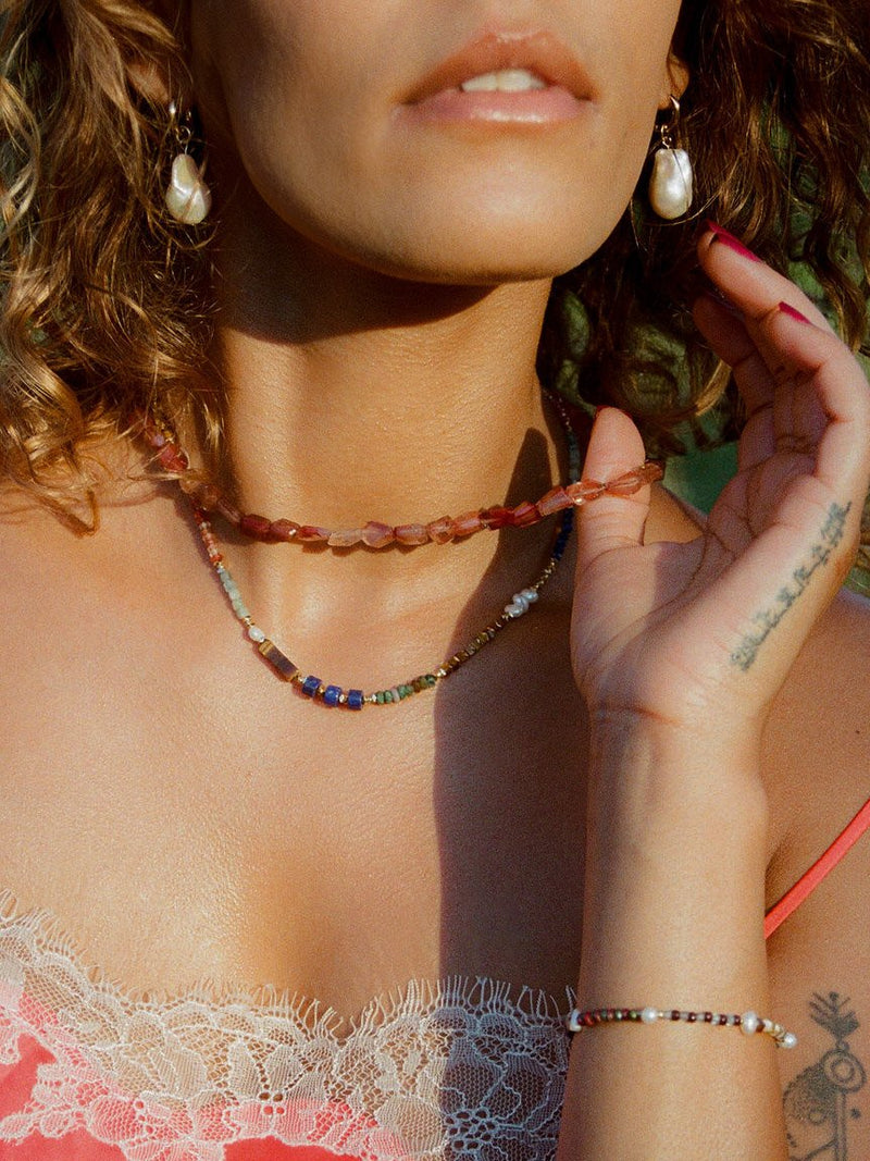 Close up of model wearing Luxe Baby Gems necklace and faceted andesine necklace.