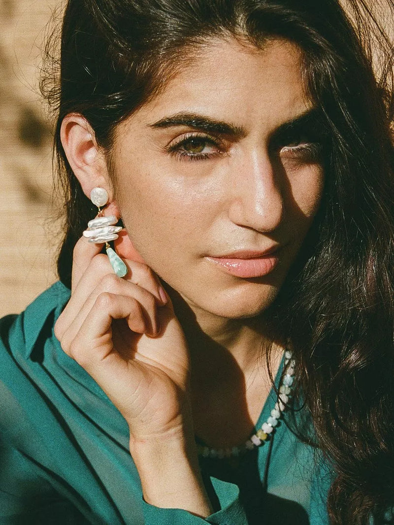 Woman adjusting an earring with a blurred background