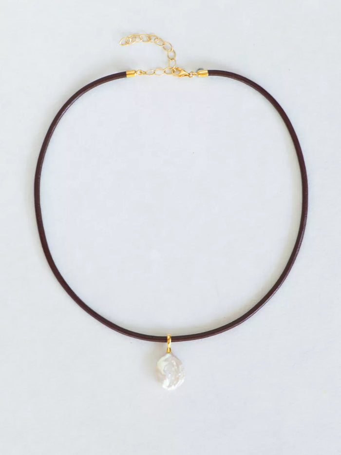 Leather necklace with pearl drop pendant and gold chain.