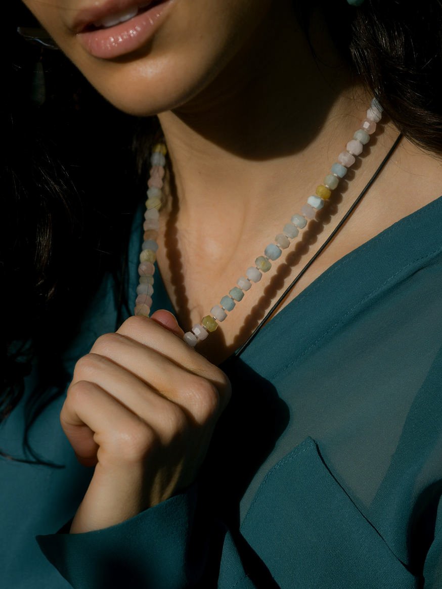 Model wearing a multicolor beaded necklace and turquoise shirt.