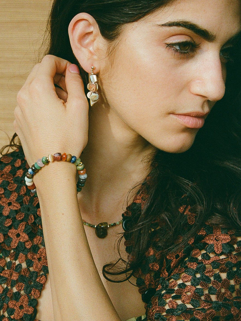 Close up of model wearing multicolored stretch bracelet.