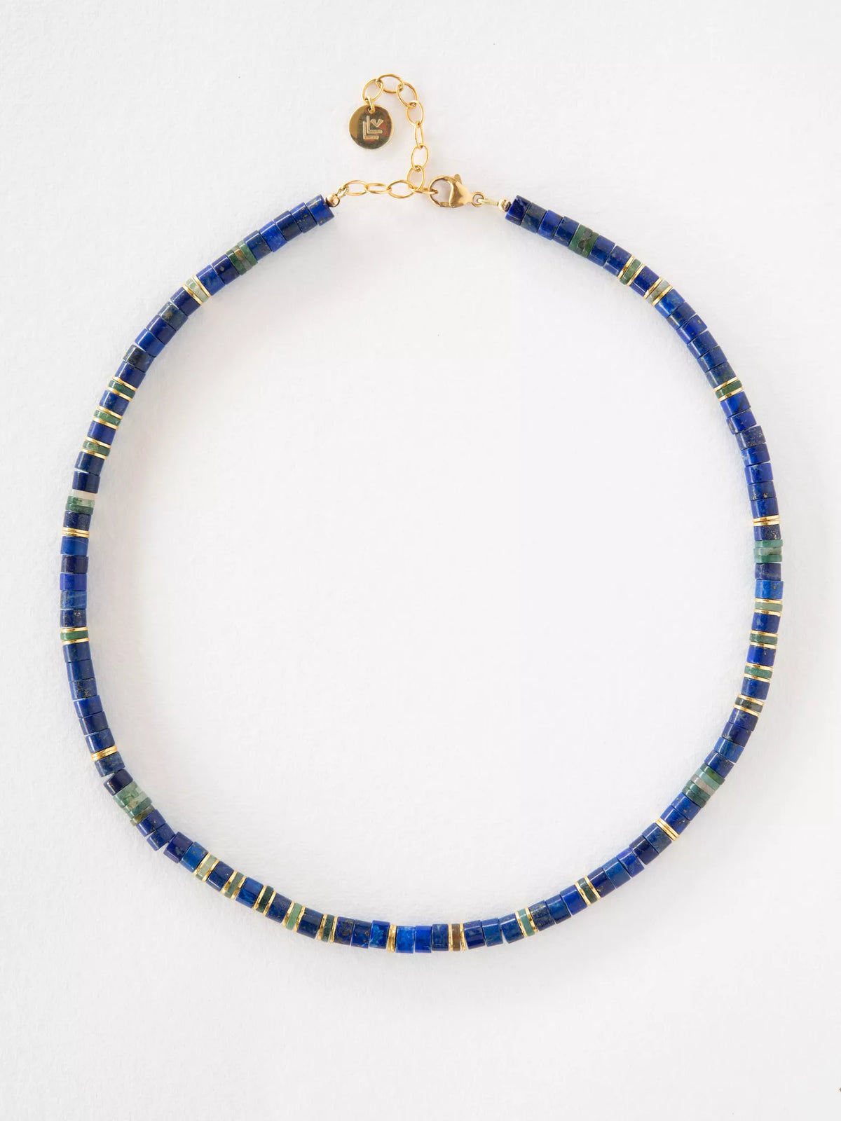 Necklace with blue lapis beads and gold accents on a white background