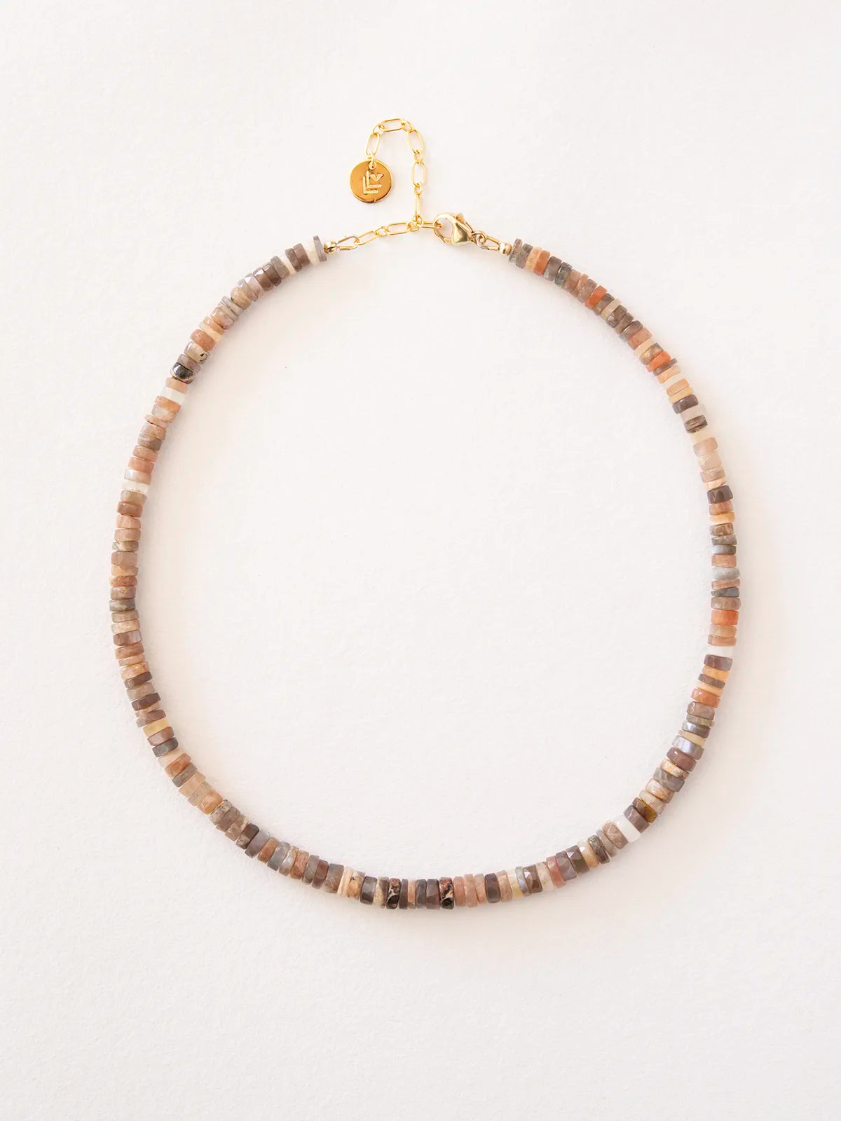 A beaded necklace made of small, irregular stone beads in earthy brown, beige, and gray tones, finished with a gold-filled clasp and chain, shown on a plain white background.