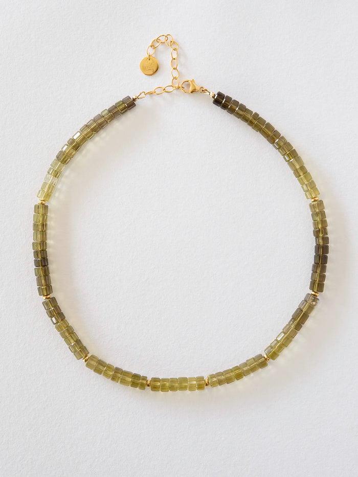 A beaded necklace made of olive green translucent beads with gold-filled chain and clasp, displayed on a clean white background.