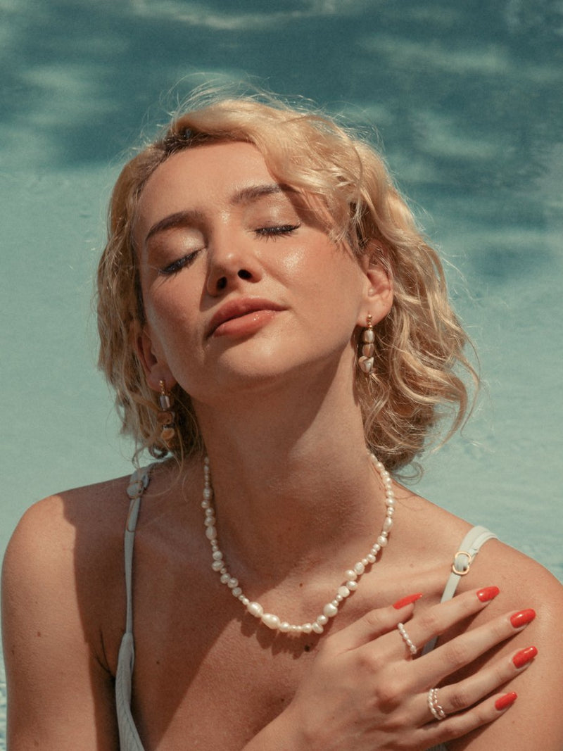 Model wearing mother-or-pearl hoop earrings