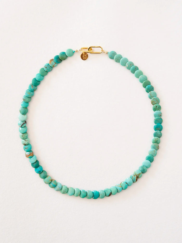 Necklace made of round turquoise beads connected by a gold-filled, reversible clasp, photographed on a plain light background.