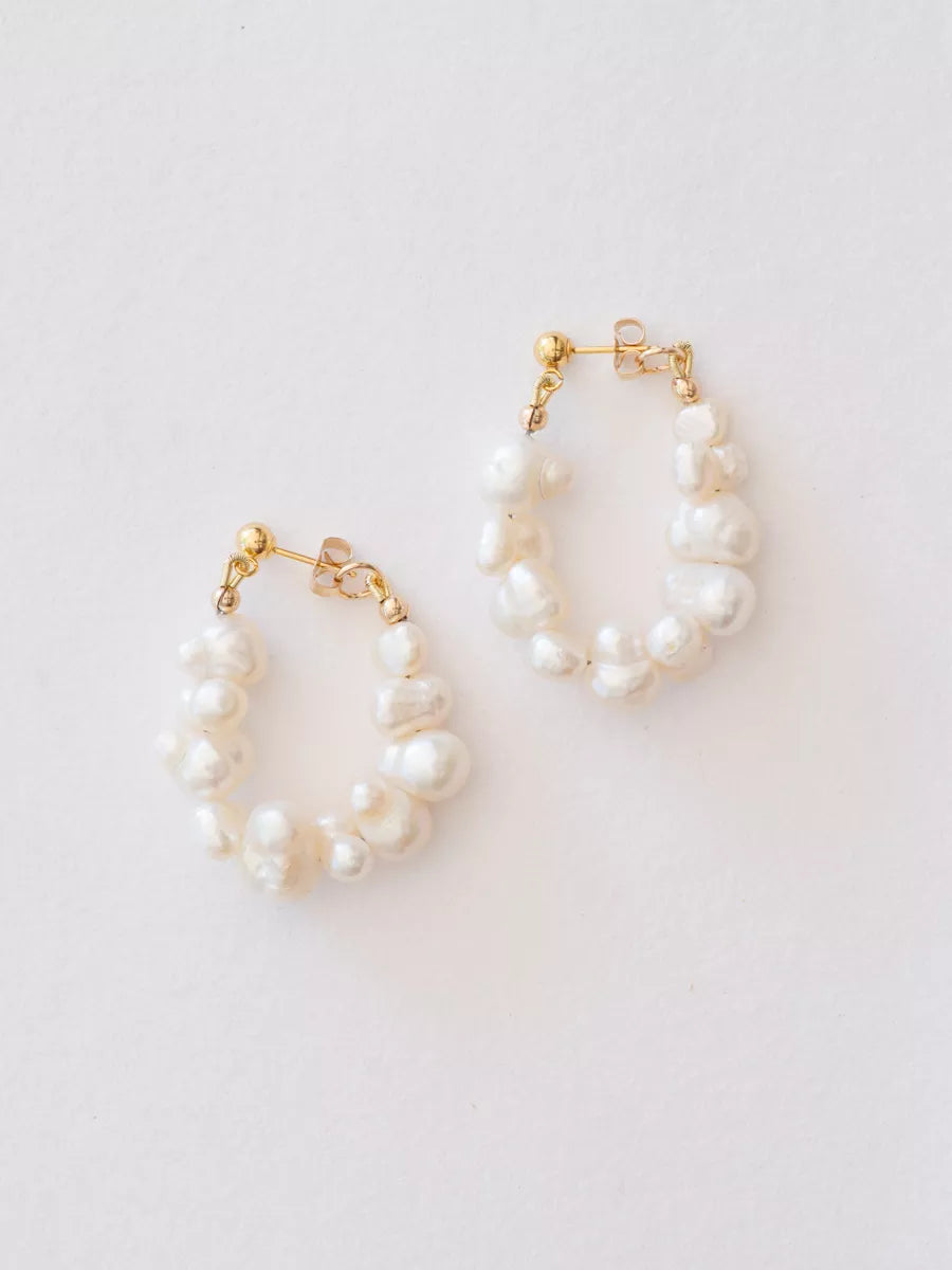 Pearl hoop earrings on a light gray background