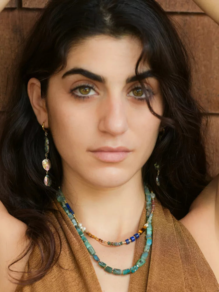 Woman wearing a necklace with a brown background