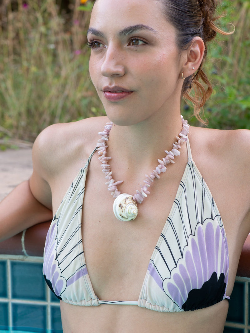 Model wearing secret beach turbo shell necklace by pool
