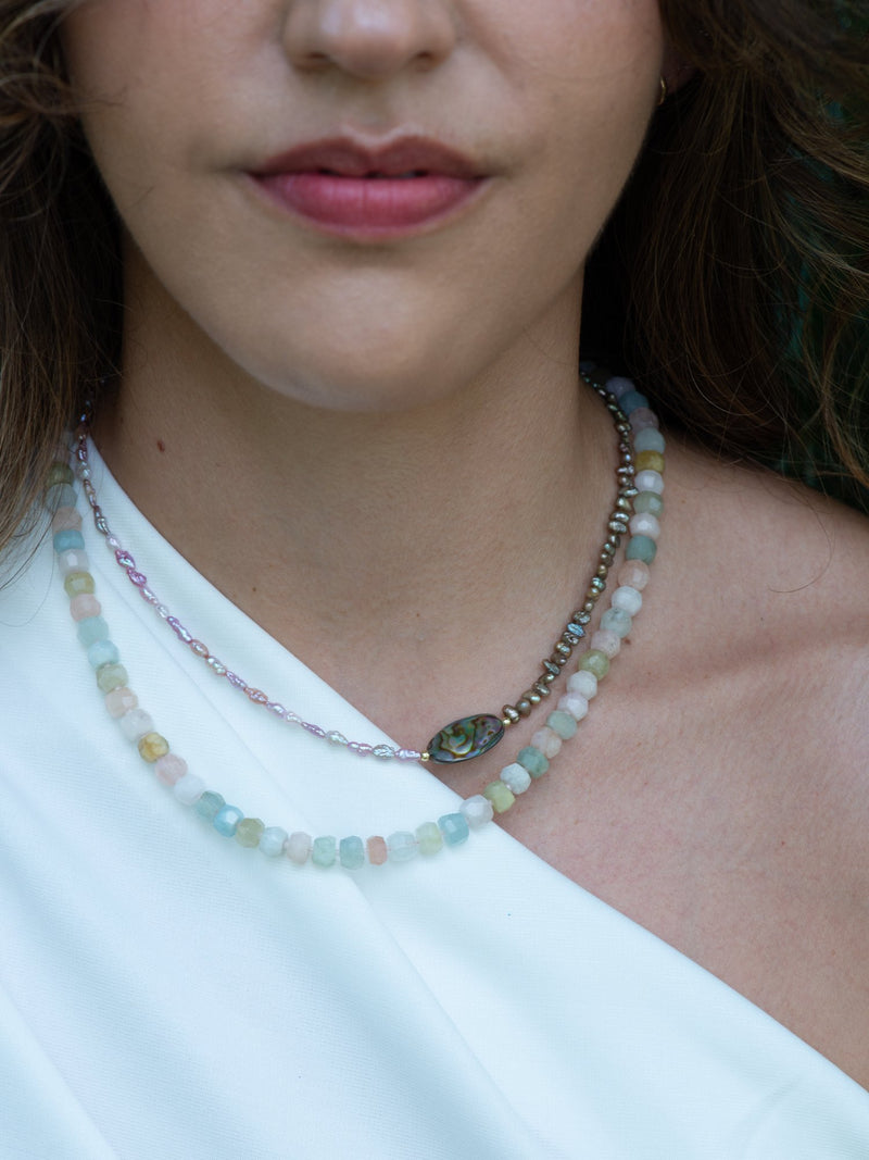 Close up of soft rock pastel beryl necklace on model