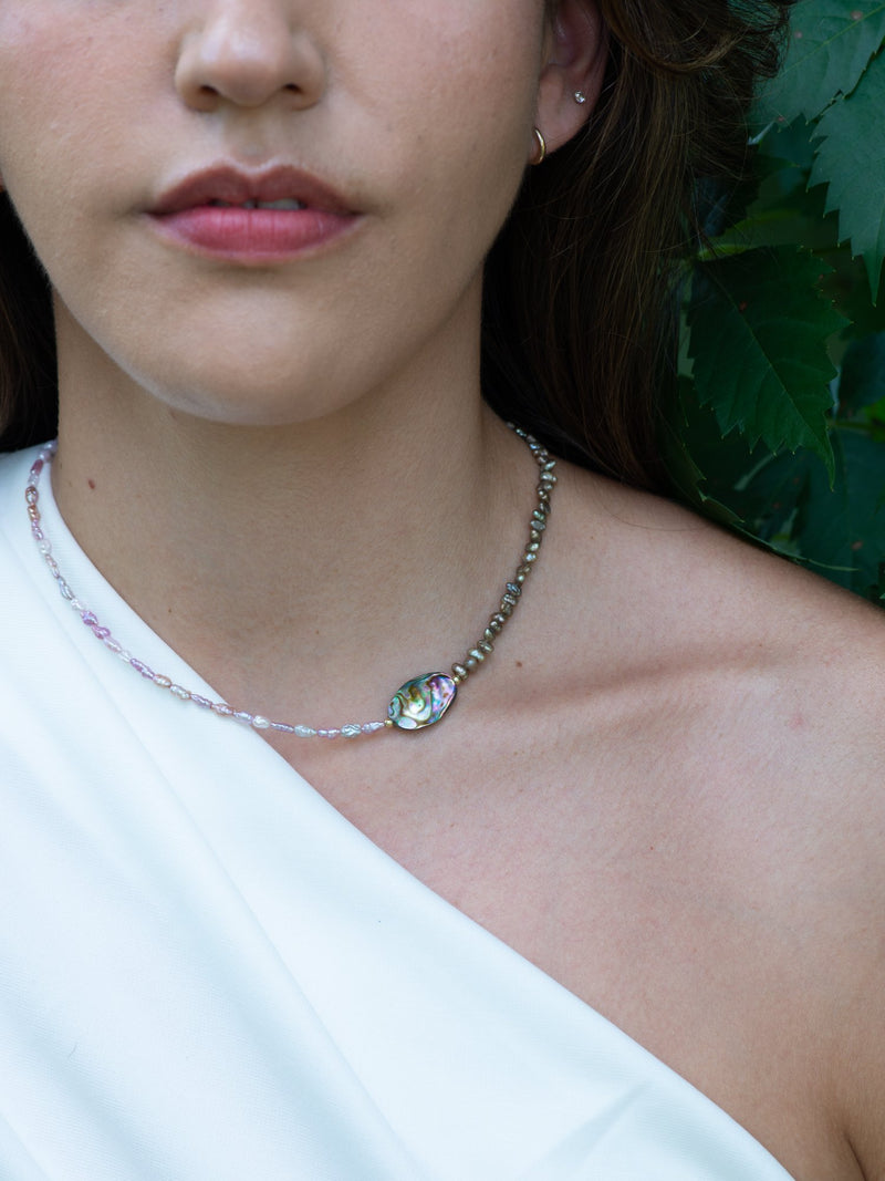 Close up of tide pool vintage pearl and abalone necklace on model